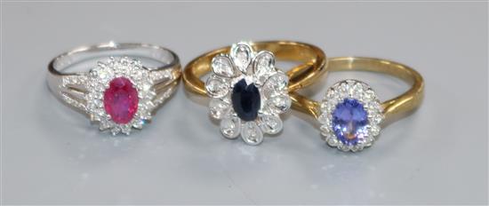 An 18ct white gold, ruby and diamond cluster ring and two other 9ct gold cluster rings.